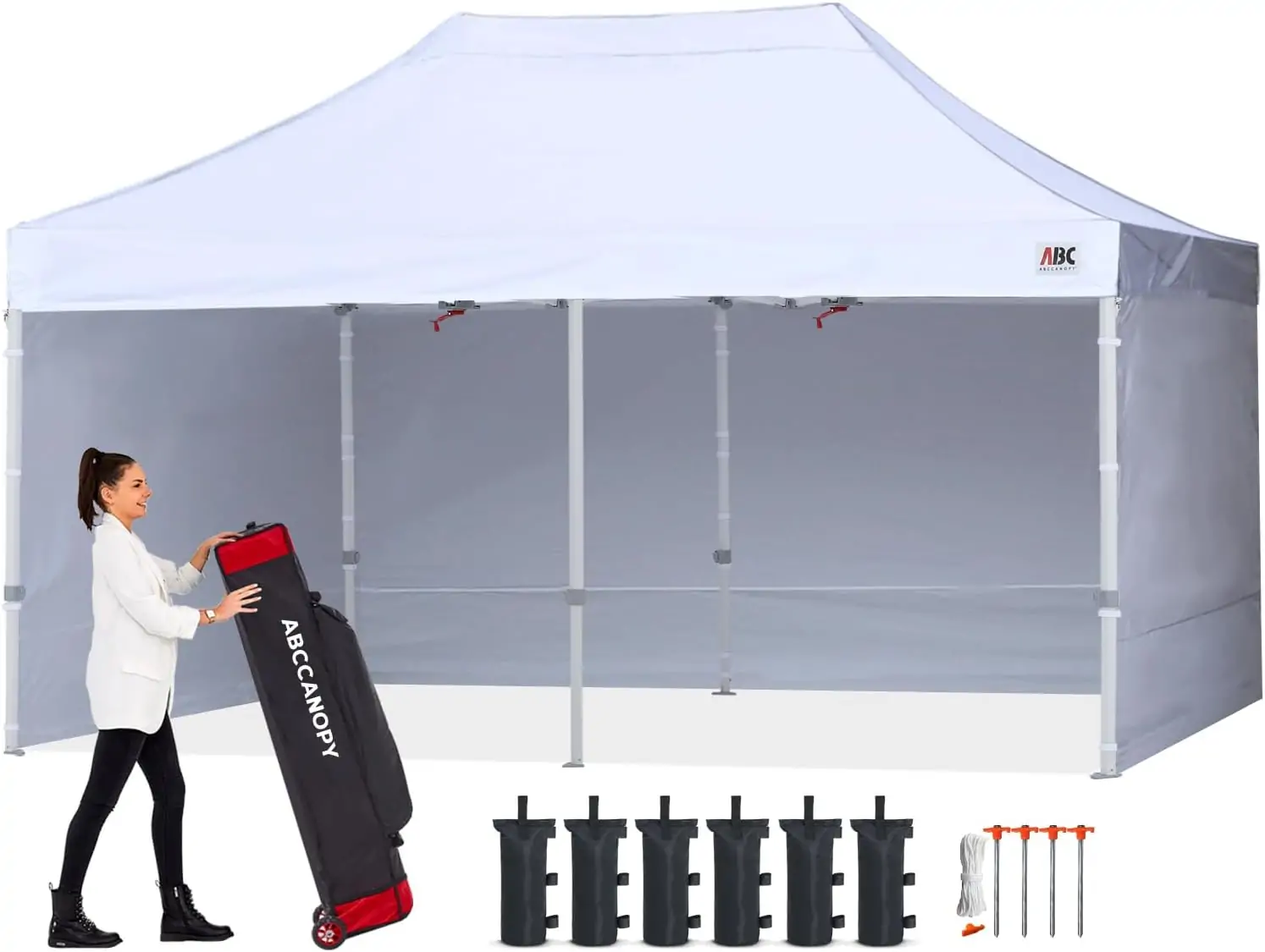 White event canopy with side walls; a woman handles an ABCCANOPY carrying bag, with weight bags and stakes arranged in front.